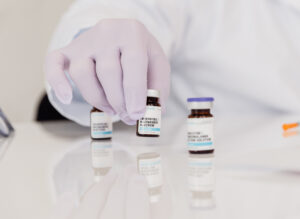 A French Med Spa + Health provider wearing purple gloves arranges vials of weight-reducing medicine in St. Charles before a patient's appointment.