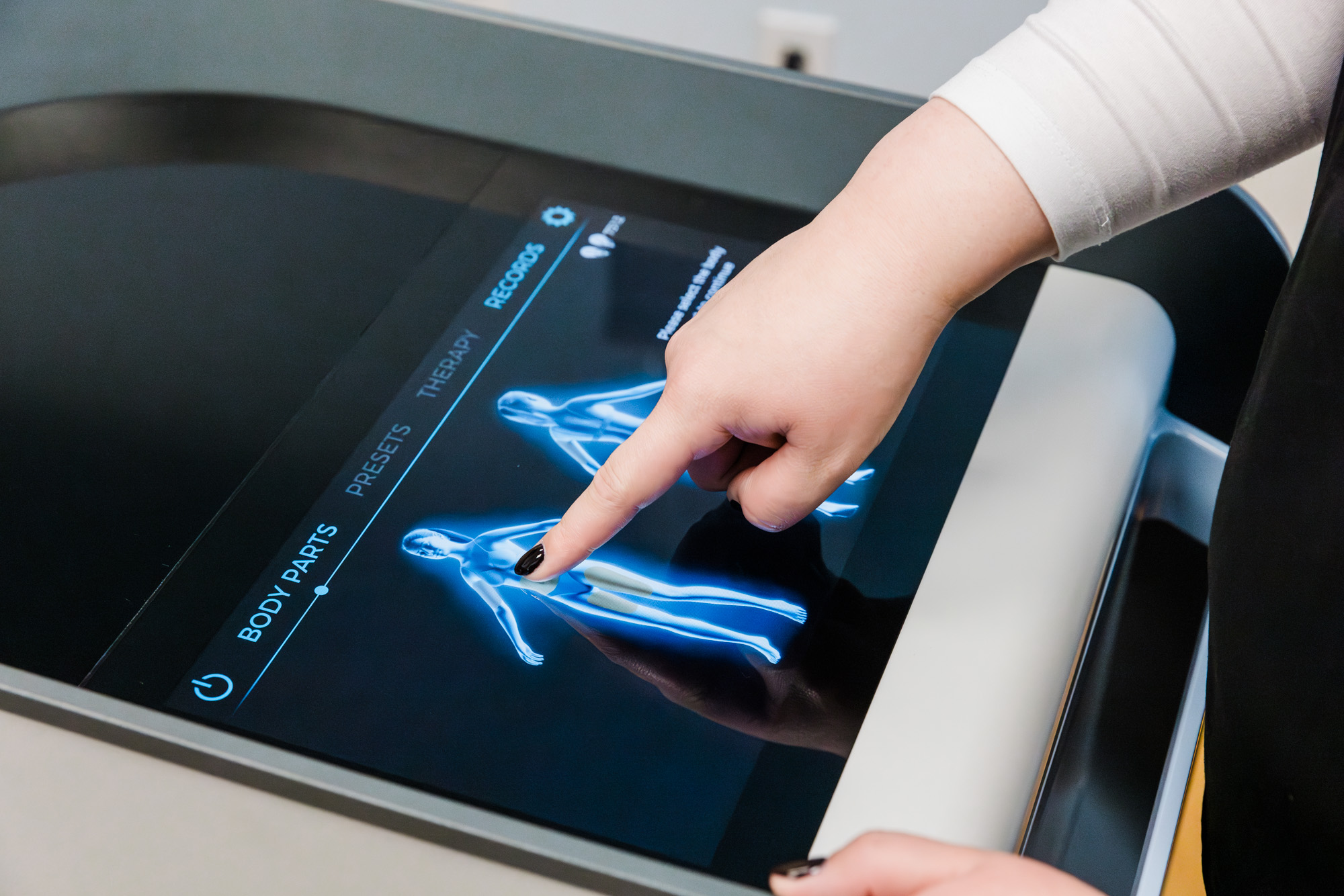 A French Med Spa + Health provider adjusts the device settings for ab sculpting in St. Charles.